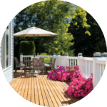 balcons en bois avec magnifique fleurs roses et une table a mangé avec un parasol ouvert en une journée ensoleillé d’été
