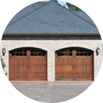 vue sur 2 portes de garage en bois d’une maison en brique